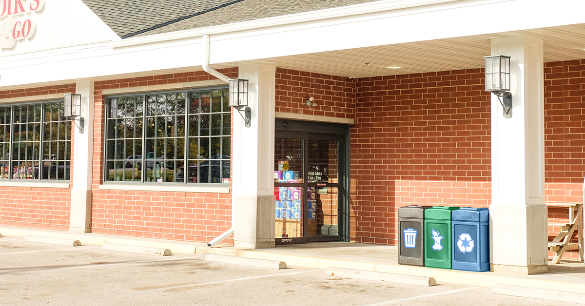 a trash, recycling and compost receptacle in front of a c-store