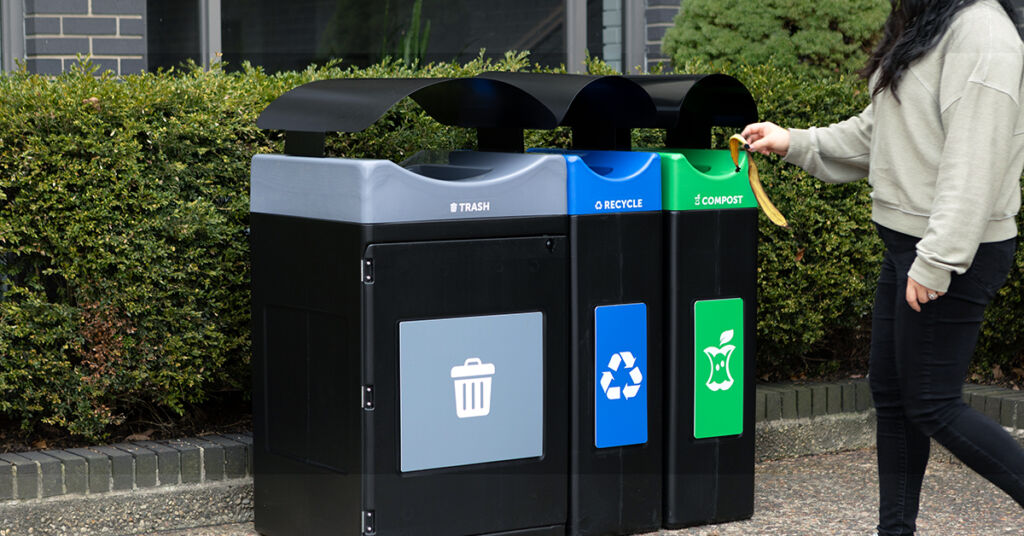 Someone using a multi-stream trash, recycling and compost receptacle outdoors